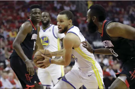  ??  ?? Golden State Warriors guard Stephen Curry (center) drives around Houston Rockets guard James Harden (right) during the first half in Game 2 of the NBA basketball Western Conference Finals on Wednesday in Houston. AP PHOTO/DAVID J. PHILLIP