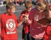  ??  ?? French Creek Elementary School teacher Tara Torres checks fourth grader, Hunter Young’s pedometer.