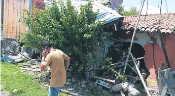  ??  ?? IMPACTO. La rastra destruyó una vivienda y sufrió daños en toda su parte frontal.