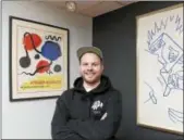  ?? ARNOLD GOLD — NEW HAVEN REGISTER ?? Justin Norman between a Mark Kostabi original crayon drawing, right, and an Alexander Calder poster, left, at his store, CT Modern, on Main Street in Branford.