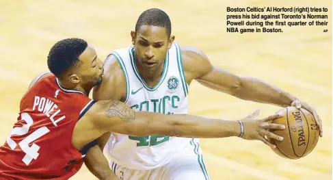  ??  ?? Boston Celtics’ Al Horford (right) tries to press his bid against Toronto’s Norman Powell during the first quarter of their NBA game in Boston.