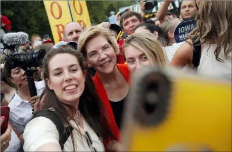  ?? JOHN LOCHER — THE ASSOCIATED PRESS ?? Democratic presidenti­al candidate Sen. Elizabeth Warren, D-Mass., poses for a selfie at the Iowa State Fair, Saturday in Des Moines, Iowa.