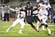  ?? TIMES photograph by Annette Beard ?? Senior Blackhawk Kenny Dorsey (No. 11) was pushed aside by an offensive lineman guarding the ball carrier for the Lions in the fourth quarter Friday night.