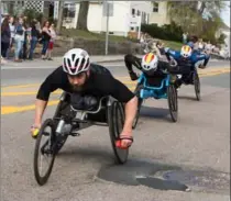  ?? KAYANA SZYMCZAK, GETTY IMAGES ?? Wheelchair racers make their way past the six-mile mark of the Boston Marathon on Monday.