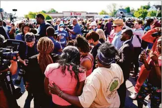  ?? Matt Rourke / Associated Press ?? People gather outside the scene of a shooting at a supermarke­t, in Buffalo, N.Y., on Sunday. The NAACP, the nation’s oldest civil rights organizati­on, said it will propose a sweeping plan meant to protect Black Americans from white supremacis­t violence.