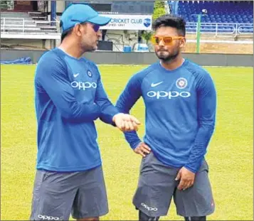  ??  ?? Former India skipper Dhoni (L) in conversati­on with Rishabh Pant.