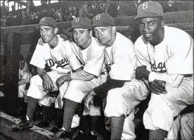  ?? ASSOCIATED PRESS FILE ?? April 15, 1947: (From left) Brooklyn Dodgers third baseman John Jorgensen, shortstop Pee Wee Reese, second baseman Ed Stanky and first baseman Jackie Robinson pose at Ebbets field in New York. Robinson plays the first major league game of his Hall of Fame career for the Dodgers, scoring the deciding run in a 5-3 victory over the Boston Braves. He becomes the first Black player to appear in the majors since 1884, changing baseball forever.