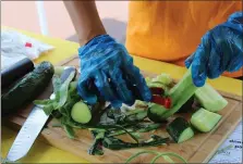  ?? MEDIANEWS GROUP FILE PHOTO ?? Chester County Food Bank intern Audrey Bova prepares cucumbers for a chilled cucumber soup during a recipe demonstrat­ion at the Fresh2You Mobile Market stop in North Coventry.