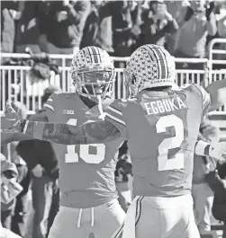  ?? JAY LAPRETE/AP ?? Ohio State receiver Marvin Harrison, left, celebrates his touchdown against Michigan with teammate Emeka Egbuka during the first half Saturday in Columbus, Ohio.