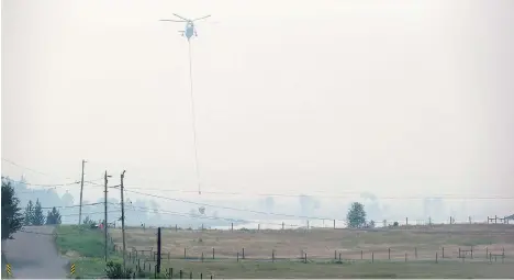  ?? DARRYL DYCK/THE CANADIAN PRESS ?? A helicopter carrying a bucket picks up water while battling the Gustafsen wildfire near 100 Mile House this week.