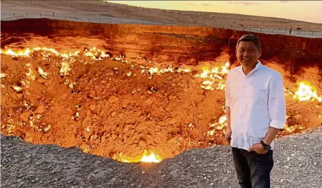  ??  ?? The writer at the darvaza Gas Crater, one of the top must-visit places in Turkmenist­an. — Photos: CLIFF LAI