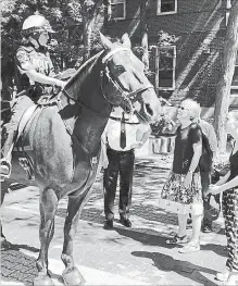  ?? HAMILTON POLICE SERVICES ?? Stephanie Curran, centre, and her daughter Ally admire Barron the horse, named after their ancestor, former Hamilton police Const. James Barron. Hamilton police Sgt. Denise Menard is in the saddle.