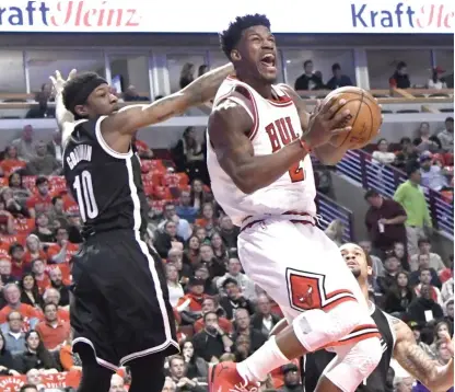  ?? | DAVID BANKS/ AP ?? Bulls forward Jimmy Butler drives past Brooklyn Nets guard Archie Goodwin during the first half Wednesday.