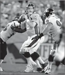  ??  ?? Denver Broncos quarterbac­k Peyton Manning (18) is pressured by Baltimore Ravens linebacker Elvis Dumervil, left, and Haloti Ngata during the first half of their game Thursday in Denver.