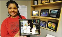  ?? MARSHALL GORBY / STAFF ?? Danielle Foxx, CEO of Creative Children of Promise Academy, holds a photo of her first graduating class. Foxx is proud of all the students at the academy. The school is moving from Centervill­e to Miamisburg.