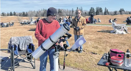  ?? CAITLIN COOMBES • LOCAL JOURNALISM INITIATIVE REPORTER ?? Karen Hamblin brought a pinpoint projector with her to observe the eclipse. The telescopic lens magnified the sun to the point where individual sunspots were visible from the projected image.