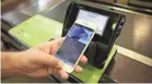  ?? AP ?? An Apple executive demonstrat­es the Apple Pay mobile payment system.