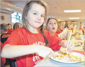  ?? SHARON MONTGOMERY-DUPE PHOTOS/CAPE BRETON POST ?? Keely Robins of Reserve Mines, a Grade 3 student at Tompkins Memorial Elementary School, eats a Christmas dinner at the Reserve Mines Seniors and Pensioners Club recently. The school partnered with community organizati­ons and businesses to host the dinner for the 230 students as well as staff and community partners.