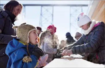  ?? @TMartinHer­ald ?? Jediah Slingerlan­d, 7, tries a taste of maple taffy from the Alberta French Canadian Associatio­n’s Maple Sugar Shack at the Helen Shuler Nature Centre as part of the Family Day festivitie­s on Monday.