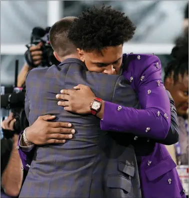  ?? JOHN MINCHILLO — THE ASSOCIATED PRESS ?? Paolo Banchero hugs family and friends after being selected number one overall by the Orlando Magic in Thursday night’s NBA Draft.