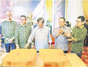  ?? ?? ULANG TAHUN: Abang Johari memotong kek sebagai simbolik sambutan Ulang Tahun Ke-10 Sakura Ferroalloy­s di Bintulu, kelmarin.