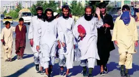  ??  ?? Afghan Taliban prisoners freed from Bagram Prison walk in Kabul, Afghanista­n, yesterday.