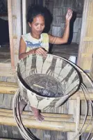  ??  ?? A woman weaves at the Mangyan village.