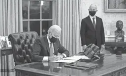  ?? EVAN VUCCI/AP FILE ?? Secretary of Homeland Security Alejandro Mayorkas looks on as President Joe Biden signs an immigratio­n executive order in the Oval Office.