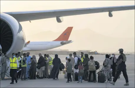  ?? BERNAT ARMANGUE — THE ASSOCIATED PRESS ?? Foreigners board a Qatar Airways aircraft at the airport in Kabul, Afghanista­n, Sept. 9. Some 200foreign­ers, including Americans, flew out of Afghanista­n on an internatio­nal commercial flight from Kabul airport on Thursday, the first such large-scale departure since U.S and foreign forces concluded their frantic withdrawal at the end of last month.