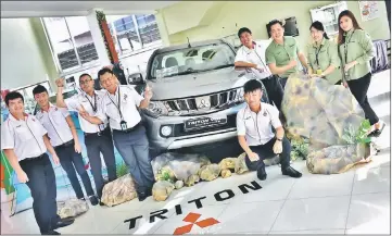  ??  ?? Jimisar Autotrade sales manager Sim Hock Sing (third right) and colleagues give the thumbs-up to the refreshed Mitsubishi Triton.