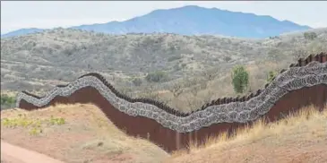  ?? AFP ?? A general view of the border fence, covered in concertina wire, separating the US and Mexico, on the outskirts of Nogales, Arizona.