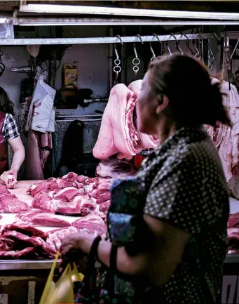  ??  ?? FAMILIAR PATTERN
A virus that lives in animals makes the jump to humans, people pass the infection around, plane travel spreads disease far and wide, and a crisis erupts. Left: a butcher's stall in Shanghai. Bottom: crew members disinfect a Thai Airways airplane.