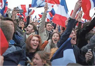  ?? THIBAULT CAMUS, AP ?? Supporters of Emmanuel Macron celebrate Sunday near the Louvre in Paris, singing “we have won, we have won” after Macron was easily elected president following a divisive campaign.