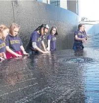  ?? JADA YUAN/THE NEW YORK TIMES ?? Students examine the Southern Poverty Law Centre’s Civil Rights Memorial, designed by Maya Lin, in Montgomery, Ala. The area has a complicate­d history, heavy with racial tensions.