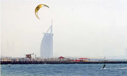  ?? Photo by Dhes Handumon ?? A man enjoys kite surfing on a hazy afternoon at the Kite Surf Beach in Dubai. —
