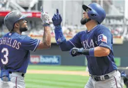  ?? Hannah Foslien / Getty Images ?? The Rangers’ Delino DeShields (right) congratula­tes teammate Robinson Chirinos on a two-run home run against Minnesota on Saturday.