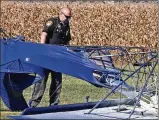  ??  ?? A Clark County Sheriff’s deputy looks over the remains of a single-engine airplane that crashed while landing and burst into flames Oct. 13 at the New Carlisle Airport.