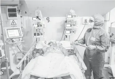  ?? — Gambar AFP ?? ANGKA PALING TINGGI: Seorang jururawat profesiona­l membantu seorang pesakit COVID-19 yang menerima rawatan rapi di Hospital Virgen de Fatima di utara Peru.