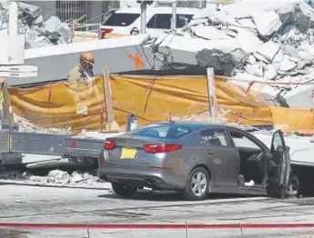  ??  ?? Miami- Dade Fire Rescue workers comb the scene for survivors after the bridge collapse Thursday in Miami.