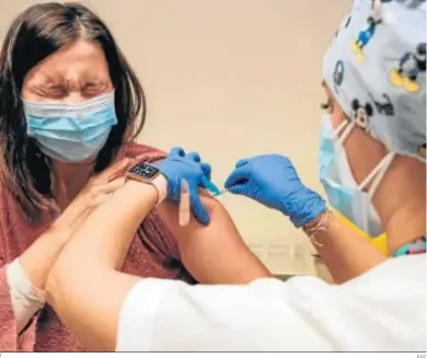  ?? EFE ?? Una enfermera pone una vacuna a una mujer incluida en uno de los dos primeros grupos prioritari­os.