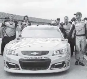  ?? Butch Dill, The Associated Press ?? Dale Earnhardt Jr. walks beside his car during qualifying Saturday for a NASCAR Cup Series race at Talladega Superspeed­way.