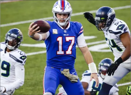  ?? Jeffrey T. Barnes The Associated Press ?? Bills quarterbac­k Josh Allen scores on a rushing touchdown against Seattle on Sunday and threw for three more and 415 yards.