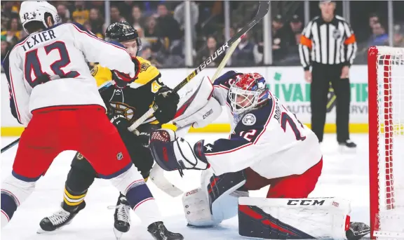  ?? THE ASSOCIATED PRESS ?? Columbus centre Alexandre Texier and goaltender Sergei Bobrovsky try to keep Boston Bruins centre Danton Heinen away from the puck Thursday. Boston won 3-2.