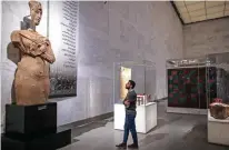  ??  ?? A visitor looks at a large statue of the 18th dynasty Pharaoh Akhenaten.