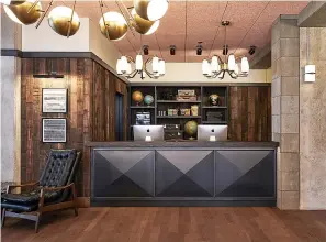  ?? Associated Press ?? ■ This photo shows the lobby in The Hoxton Hotel in Portland, Ore. Tailored but comfy mohair and leather seating and warm wood side tables blend with distressed rugs and displays of ceramics, plants and books. Refurbishe­d timber and concrete beams frame the spaces.