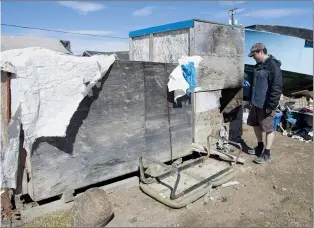  ?? CP PHOTO ADRIAN WYLD ?? Quamariaq Inuqtaqau checks to see if a homeless elder is at his shack in Iqaluit, Nunavut on June 28. The latest release of data from the 2016 census shows Canada’s Indigenous population is booming, more immigrants are settling in the Prairies and home...