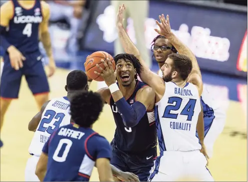  ?? John Peterson / Associated Press ?? UConn’s Isaiah Whaley (5) drives to the basket against Creighton’s Mitch Ballock (24) and Damien Jefferson (23) in the second half on Saturday.