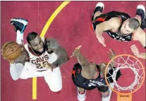  ?? AP PHOTO ?? Cleveland Cavaliers’ Lebron James shoots as Toronto Raptors’ Anunoby and Jonas Valanciuna­s, right, defend during NBA action Tuesday, April 3, in Cleveland.