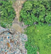  ??  ?? A flock of birds fly over plastic waste at a collection site in Alue Lim village in Lhokseumaw­e, Indonesia.