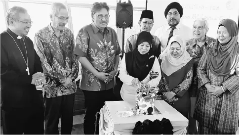  ??  ?? Zabariah cuts IIC’s ninth anniversar­y cake surrounded by the guests.